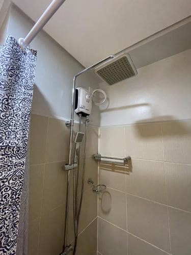 y baño con ducha y cortina de ducha. en Grass Residences Charming Staycation, en Manila