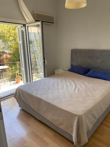 una camera da letto con un letto con cuscini blu e una finestra di Johnny house ad Atene