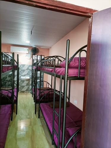 a group of bunk beds in a room with purple sheets at Westminster Holiday home in Merces