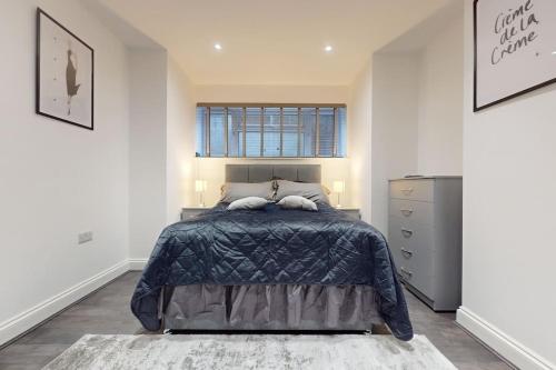 een slaapkamer met een groot bed en een raam bij LONDON STAY Flats in Londen
