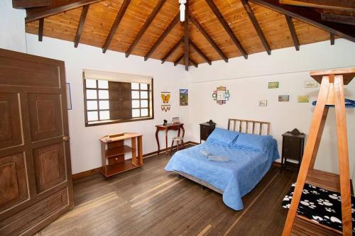 a bedroom with a blue bed and a wooden door at Hermosa Casa de Campo los Montes en Zapatoca in Zapatoca