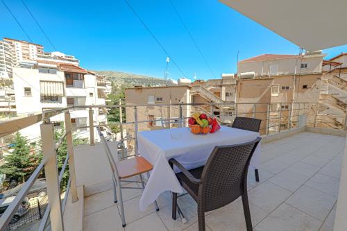 a table with a bowl of fruit on a balcony at Valentina Apartment 1 in Sarandë