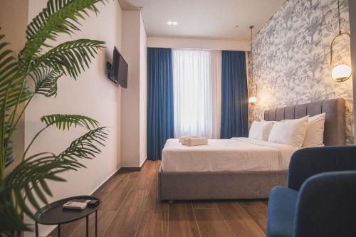 una camera d'albergo con letto e pianta di Downtown Suites by Athens Tower Hotel ad Atene