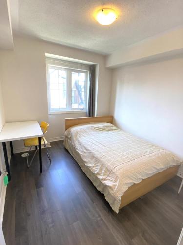 a bedroom with a bed and a desk and a window at Aiyifan12138 in Waterloo