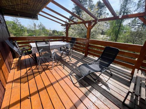 a wooden deck with chairs and a table on it at Chata Dagmar in Třebíč