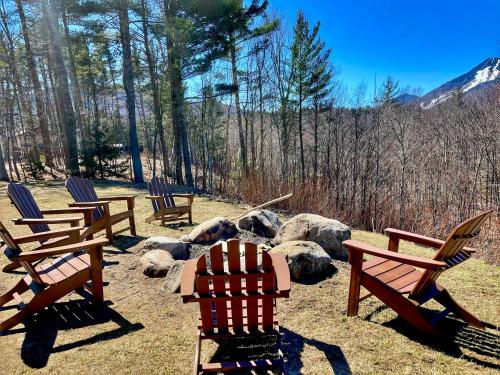 a group of wooden chairs sitting in a field at Algonquin Mountain Chalet in Wilmington