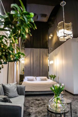 CzerwionkaにあるHotel Biały Domのベッドとソファとテーブルのある寝室