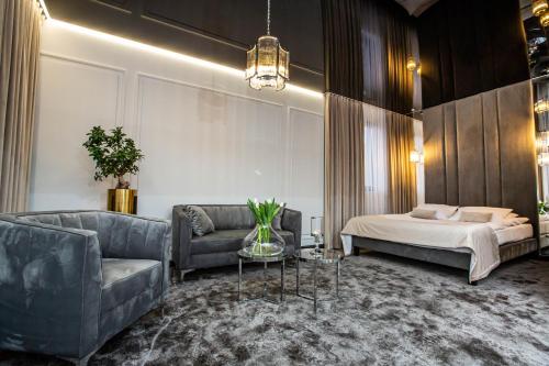 - une chambre avec un lit, un canapé et une table dans l'établissement Hotel Biały Dom, à Czerwionka