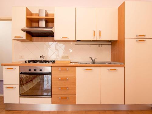 een keuken met witte kasten en een fornuis bij Apartment Tramonto su Capri by Interhome in Massa Lubrense