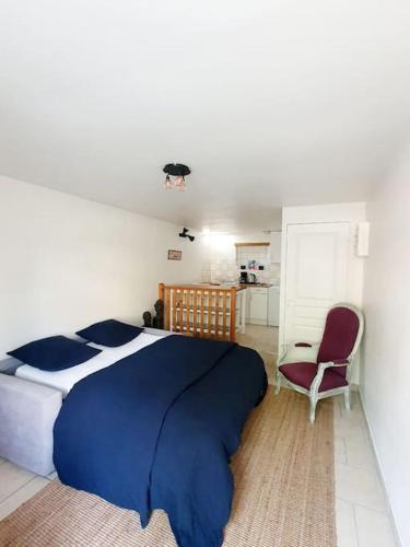 - une chambre avec un lit bleu et blanc et une chaise dans l'établissement Studio Cozy Dinard - 5 min de la plage, à Dinard