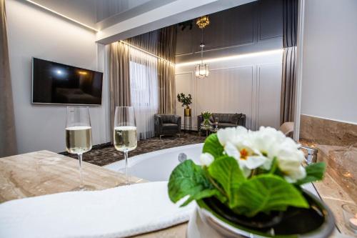 CzerwionkaにあるHotel Biały Domのバスルーム(バスタブ付)、ワイン2杯