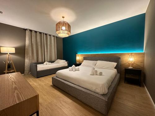 um quarto com 2 camas e uma parede azul em Dimora Del Ragno em Tivoli