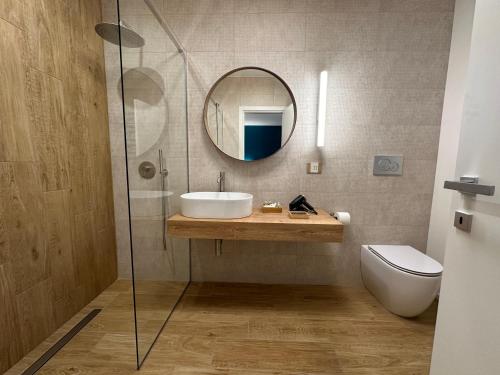 a bathroom with a sink and a mirror and a toilet at Dimora Del Ragno in Tivoli