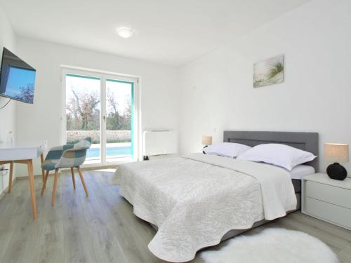 Holiday Home Skelin by Interhome في Drinovci: غرفة نوم بيضاء مع سرير ومكتب