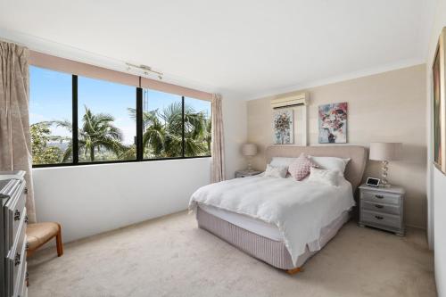 a bedroom with a bed and a large window at Tarquin - Harbour Views in Sydney