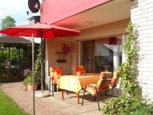 奧爾珀的住宿－Gemütliche Ferienwohnung in Eichhagen mit Grill, Terrasse und Garten，庭院配有桌椅和遮阳伞。