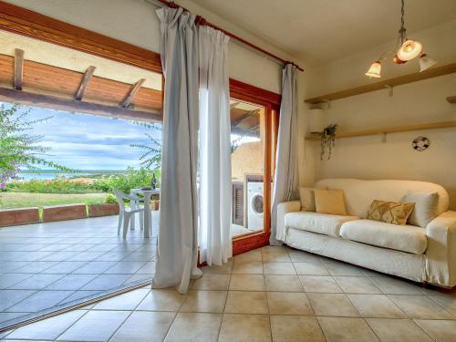 a living room with a couch and a patio at Apartment 0-5-F - Marineledda by Interhome in Golfo Aranci