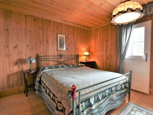 a bedroom with a bed in a room with wooden walls at Chalet Chalet Franca by Interhome in Madesimo