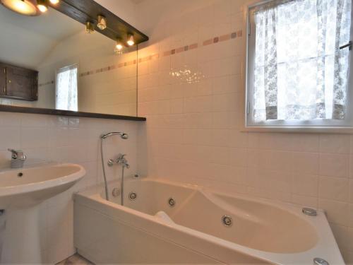 a white bathroom with a tub and a sink at Chalet Chalet Franca by Interhome in Madesimo