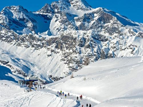 a group of people skiing down a snow covered mountain at Chalet Chalet Franca by Interhome in Madesimo