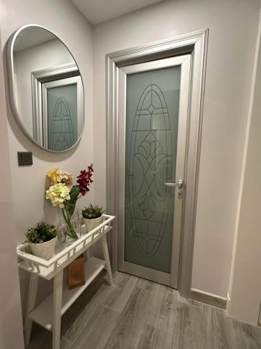 a hallway with a door with a mirror and flowers at Rose 3 in Al Khobar