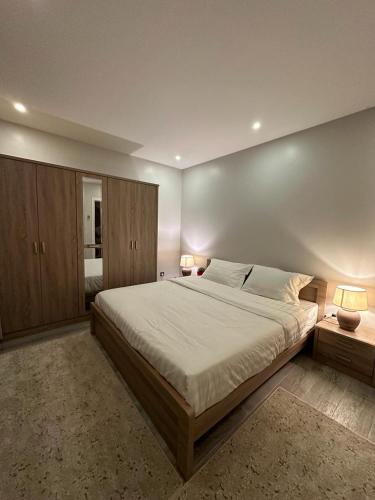 a bedroom with a large bed and two night stands at Rose 3 in Al Khobar