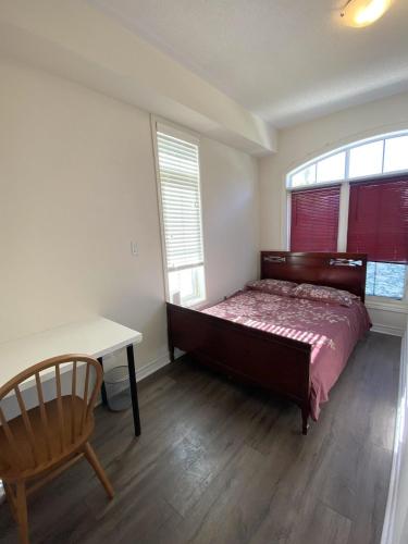 a bedroom with a bed and a desk and two windows at Aiyifan12138 in Waterloo
