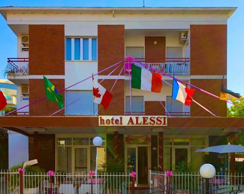 a hotel alessitz with flags in front of a building at Hotel Alessi** Rimini in Rimini