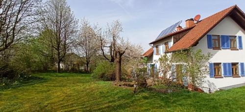 ein weißes Haus mit blauen Fenstern und einem Hof in der Unterkunft BR-Ferienwohnung Brombachtal in Langen-Brombach