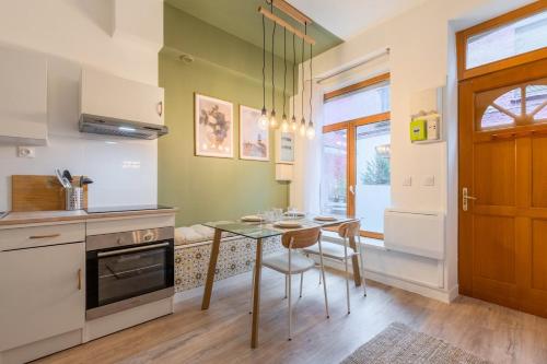 - une cuisine avec une table, des chaises et une porte dans l'établissement 1 bedroom courtyard house typical of Old Lille, à Lille