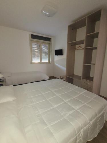Un dormitorio con una gran cama blanca y una ventana en HOUSE AIRPORT VINCENZO APP.7 - APP.8 en Catania