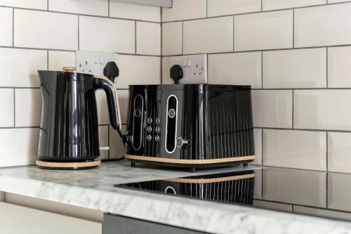 two coffee makers on a counter in a kitchen at Lovely 2 Bedroom House - Free Parking - Accommodation near QMC Hospital & University of Nottingham - Suitable for Short Stays & Long Stays in Nottingham