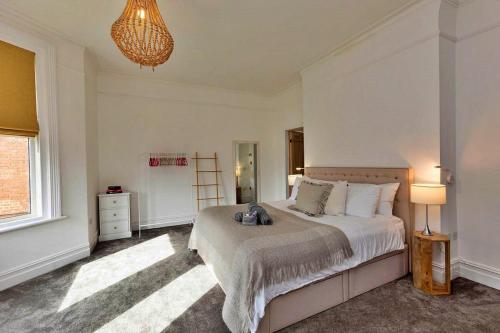 ein Schlafzimmer mit einem Bett, einer Lampe und einem Fenster in der Unterkunft Finest Retreats - Portland House in Exmouth