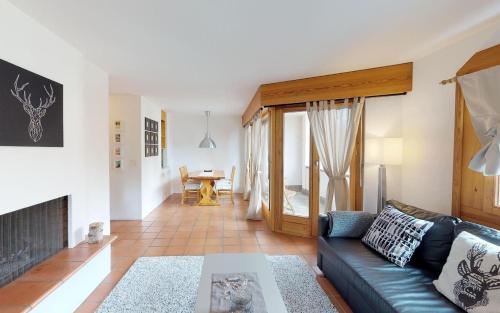 ein Wohnzimmer mit einem Sofa und einem Kamin in der Unterkunft Maurus A3 in St. Moritz