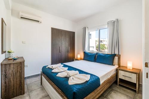 a bedroom with a large bed with blue pillows at Ayia Napa Central Apartment by Ezoria Villas in Ayia Napa