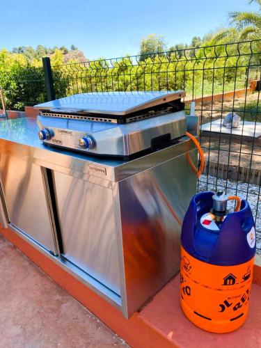 a grill with a blue container next to it at Relais Pollo Loco in Valencia