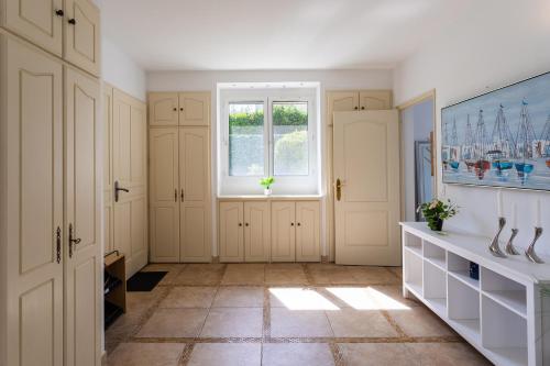 une cuisine avec des armoires blanches et une fenêtre dans l'établissement VILLA COTE SUD VI4402 By Riviera Holiday Homes, à Cagnes-sur-Mer