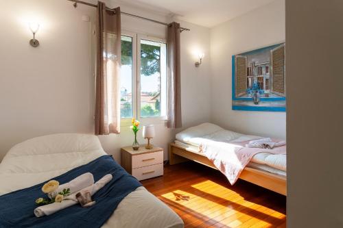 une chambre avec deux lits et une fenêtre dans l'établissement VILLA COTE SUD VI4402 By Riviera Holiday Homes, à Cagnes-sur-Mer