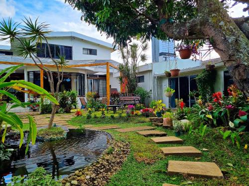 a garden with a pond in front of a house at Casa Jardin del Mango in San José