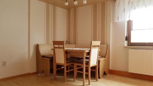 uma mesa de jantar e cadeiras num quarto em Ferienwohnung mit Gartenterrasse in der Nähe vieler Wanderwege und Ausflugsziele em Schwarzatal