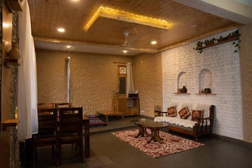 a living room with a couch and a table at Rustic Roots Home Stay in Nagar