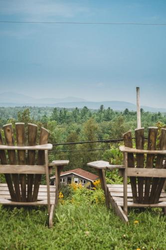 two wooden chairs sitting on top of a field at Hotel de l'Horizon in Sutton