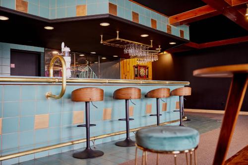 a bar with stools in front of a counter at Hotel de l'Horizon in Sutton