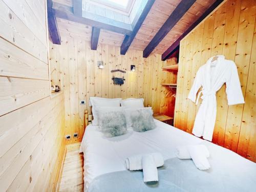 una camera da letto con un letto in una parete di legno di Spacieux Chalet 19pers, Piscine, Jacuzzi, Sauna & Salle de Jeux a Champagny-en-Vanoise