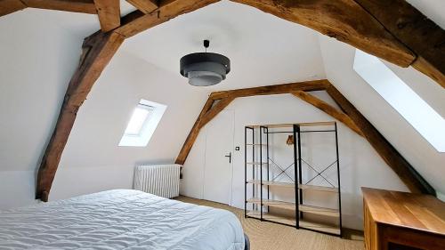 um quarto no sótão com uma cama e uma porta em Moulin de charme Touraine #insolite #nature em Rivarennes