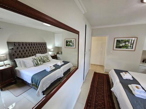 a large mirror in a bedroom with a bed at Jasmine Guest Cottage in Benoni