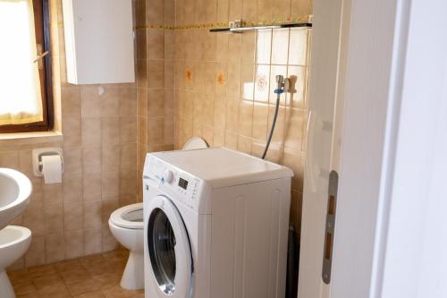 ein Badezimmer mit einer Waschmaschine und einem WC in der Unterkunft Trilocale 37 Residence La Giungla in Falerna