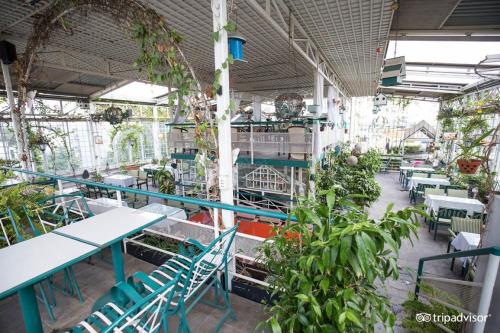 a greenhouse with tables and chairs and plants at Khách sạn Minh Châu - Hòa Hưng in Ho Chi Minh City