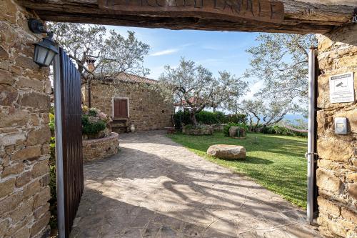 an open door to a stone house with a yard at Bellezza In Cilento Panoramic Apts in Castellabate