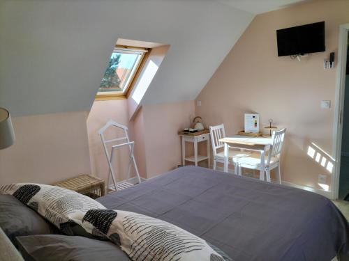 Schlafzimmer mit einem Bett und einem Tisch mit Stühlen in der Unterkunft Étape au Chemin des Dames - Chambre et table d'hôtes in Pontavert